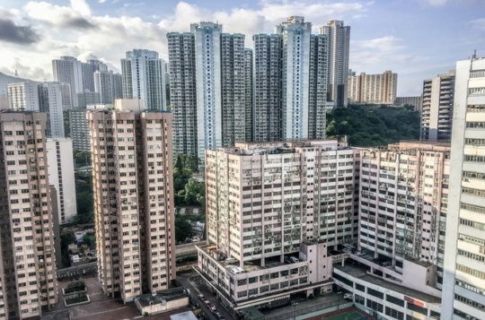 A wide angle shot of several buildings of Hong Kong built next to each other during daytime
